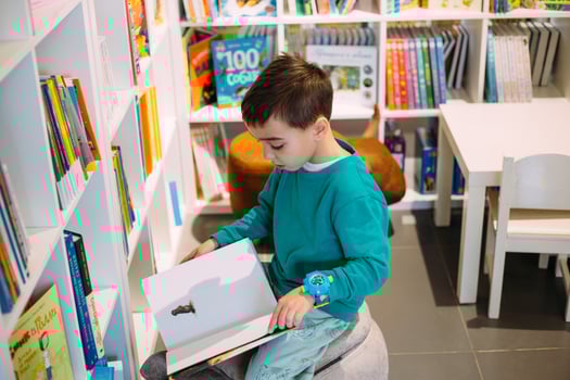 A little boy reaches for shelf of children's books in the bookstore. photo