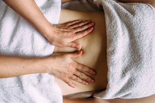 The masseur gives a massage to the female belly at the spa. The concept of cosmetic procedures. photo