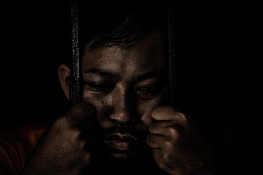 Asian man desperate at the iron prison,prisoner concept,thailand people,Hope to be free,Serious prisoners imprisoned in the prison photo