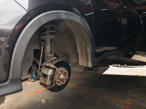 Lift is lifting a black car, removing the wheels, a car suspension repair concept. tire change photo