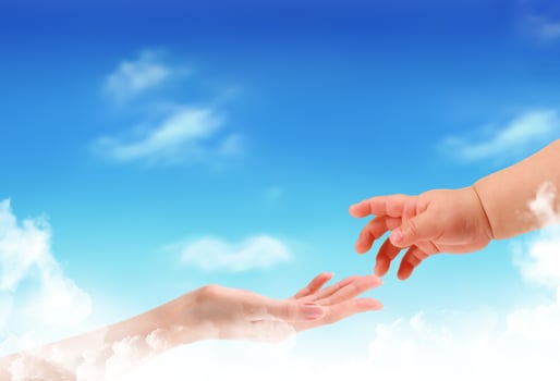 The children's hand reaches for a mother's hand against the blue sky photo