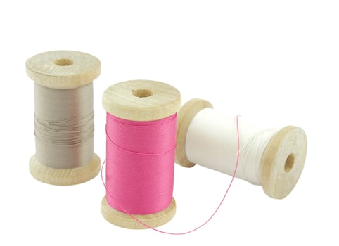Isolated wooden spools of thread with a needle photo