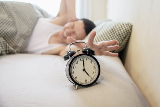 Sleepy man holding the alarm clock in the morning with late wake up - every day life at home concept photo