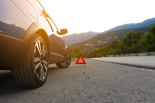 An emergency stop sign of a vehicle is installed on the road, next to the car. Copy space. photo