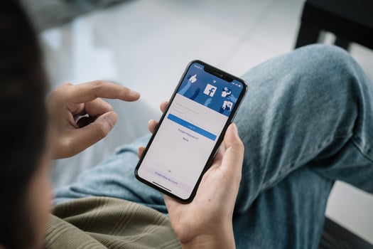 Facebook social media app logo on login signup registration page on mobile app screen on iPhone X 10 in person's hand working on ecommerce shopping business. photo