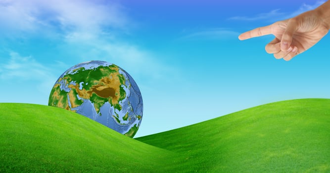 a hand with a globe and a grass field photo