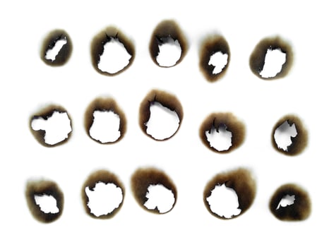 Hole paper with burned edges on white background photo