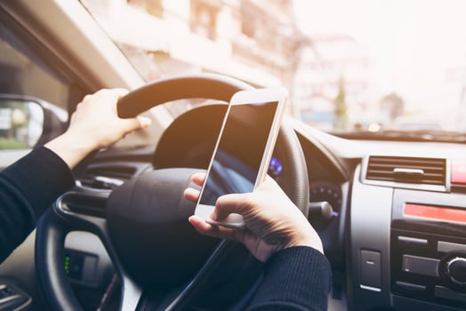 Close up of a woman driving car dangerously while using mobile phone photo