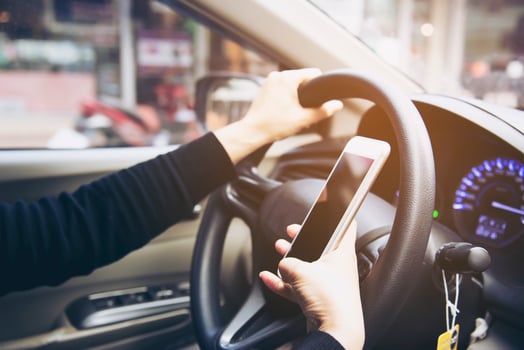Close up of a woman driving car dangerously while using mobile phone photo