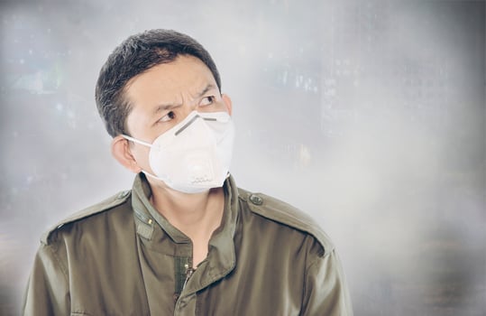 Man wearing mask protect fine dust in air pollution environment - people with protection equipment for air pollution concept photo