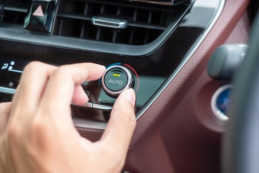 man hand adjusting temperature the air flowing during driving car on the road, air conditioner cooling system inside the car. Adjust, temperature and transport concept photo