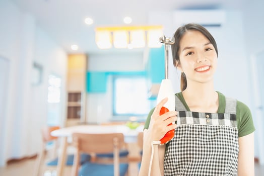 Happy lady holding kichen stuff over copy space background - people home made food preparation concept photo
