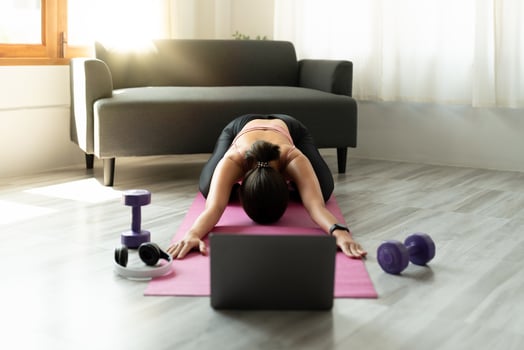Fitness instructor having virtual yoga class using video call on laptop. Remote yoga teacher leads a lesson for people photo