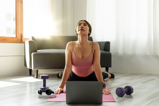 Fitness instructor having virtual yoga class using video call on laptop. Remote yoga teacher leads a lesson for people photo