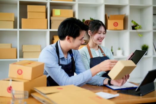 startup small business owner working with tablet at workplace. freelance man  woman seller check product order, packing goods for delivery to customer. Online selling photo