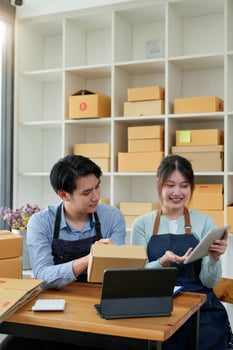 startup small business owner working with tablet at workplace. freelance man  woman seller check product order, packing goods for delivery to customer. Online selling photo