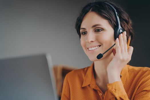 Pleasant woman Spanish speaking call center employee in wireless headset talking with client photo