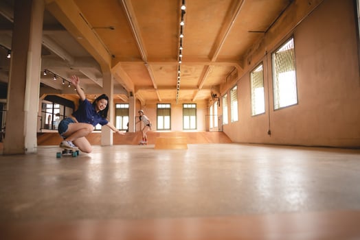 skater woman person playing skateboard in sport gym, young Asian woman are happy and fun with skateboarding lifestyle in city, teenage hipster female trendy fashion photo