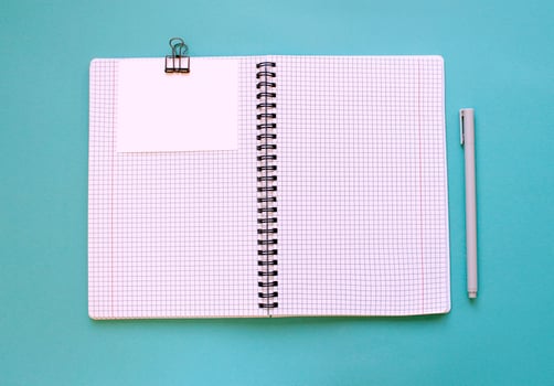Blank notebook for writing on spirals on a blue background, flat lay, the end of motivation, business, building goals with negative industrial space and copy space photo