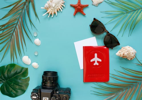 Traveler accessories, tropical palm leaf branches on background with empty space for text. Travel vacation concept. Summer background. Road frame set. Flat lay, top view. photo