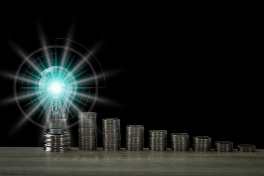 A light bulb Beside the pile of coins photo