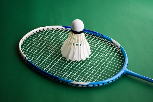Badminton sports equipments, shuttlecocks, racket, grip, on floor of indoor badminton court. photo