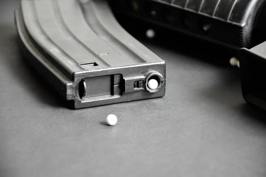 Closeup of white plastic bullets of airsoft gun or bb gun on wooden floor, soft and selective focus on white bullets. photo