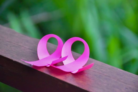 Pink ribbon on wooden table, concept for fighting against breast cancer in woman around the world. Selective focus and copy space. photo