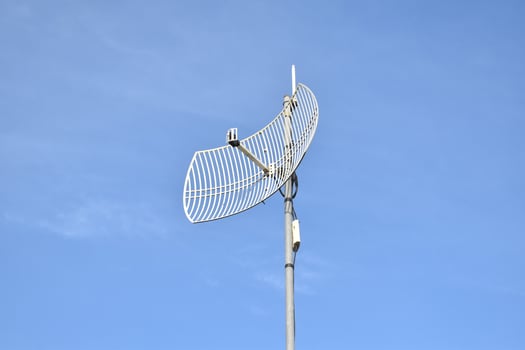 Outdoor internet wifi receiver and repeater antenna on the roof of the building with clear bluesky background. photo
