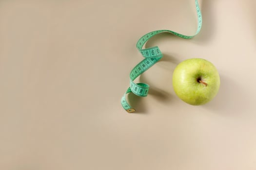 Diet concept. Apple with measuring tape photo