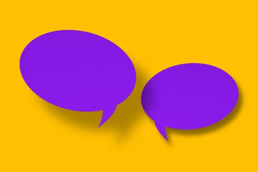 purple paper cut speech balloon shape against a yellow background. photo