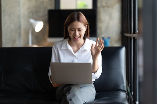 asian young woman has video chat with friends with webcam, Happy young asian business woman waving hands to greeting partner during making video conference with her team. photo