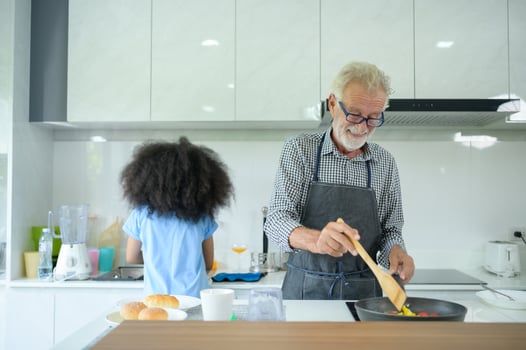 Family holiday activities with grandfather and grandchildren. Cooking dinner together for the family Grandfather is teaching cooking to his half-Asian granddaughter African American photo