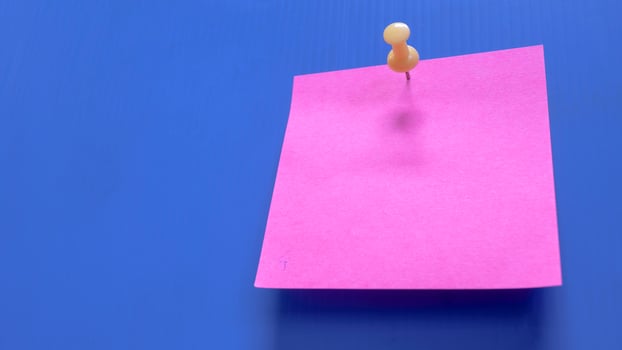 Pink note paper, isolated on a blue background. photo