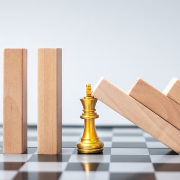 wooden Blocks or Dominoes falling to golden Chess King figure. Business, Risk Management, Solution, economic regression, Insurance photo