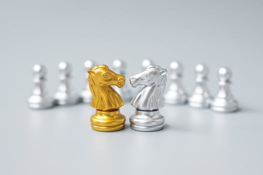 Gold and silver Chess Knight figure against pawn. Strategy, Conflict, management, business planning, tactic, politic, communication and leader concept photo