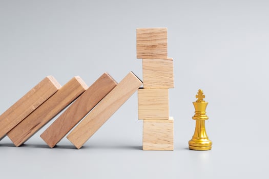 wooden Blocks or Dominoes falling to golden Chess King figure. Business, Risk Management, Solution, economic regression, Insurance photo