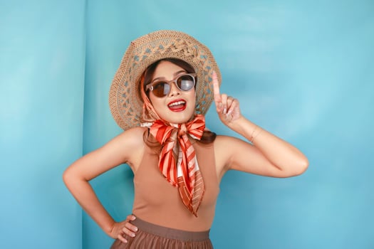 Young Asian happy woman isolated by a blue background pointing copy space upward. photo
