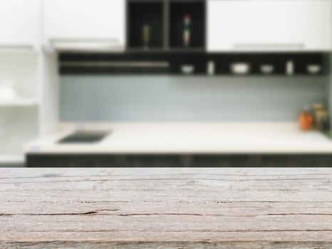 Empty wooden table and blurred kitchen background photo