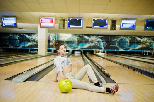 Girl with bowling ball on alley played at bowling club. photo