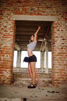 Girl wear on shorts at abadoned factoty with brick walls. photo
