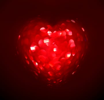 Red Blur heart shape of ligth bokeh on a black background photo