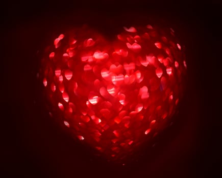 Red Blur heart shape of ligth bokeh on a black background photo