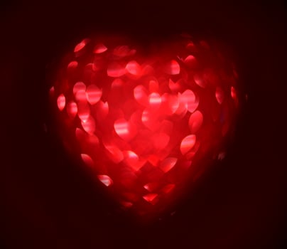 Red Blur heart shape of ligth bokeh on a black background photo