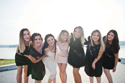 Group of 7 girls wear on black and 2 brides at hen party. photo