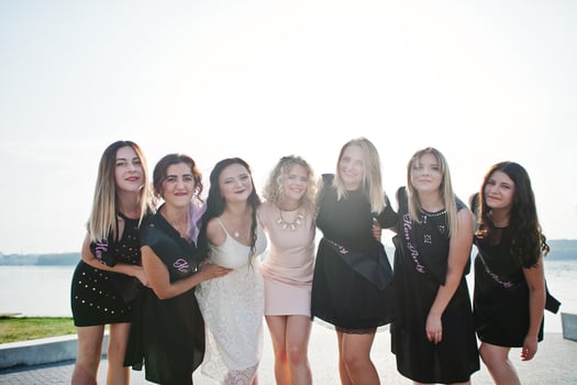 Group of 7 girls wear on black and 2 brides at hen party. photo