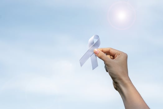 November Lung Cancer Awareness month, democracy and international peace day. Woman holding white Ribbon on sky background photo