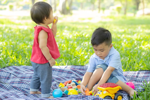 Little boy and girl is playing for idea and inspiration with toy block, kid learning with construction block for education, child activity and game in the park with happy in the summer. photo
