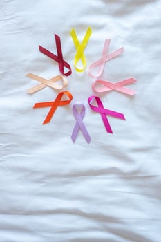 World cancer day. colorful awareness ribbons red, orange, purple, pink, peach and yellow color for supporting people living and illness. Healthcare and medical concept photo