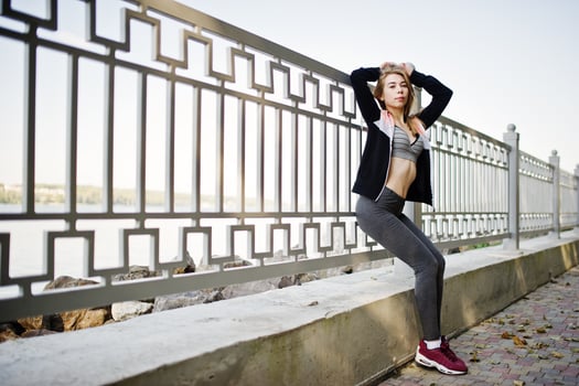 Young girl has the training and doing exercise outdoors. Sport, fitness, street workout concept. photo